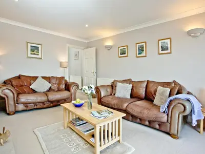 a living room with leather couches and a coffee table at Chyandour in Fowey