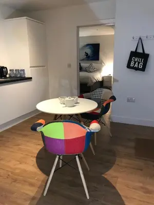 a table and chairs with a table and a bed at Waves at The Beach House in Falmouth