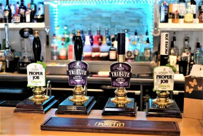 a row of three trophies sitting on a bar at Molesworth Arms in Wadebridge
