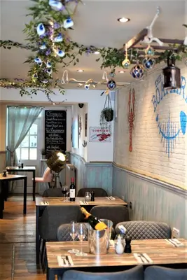 a restaurant with tables and chairs and a bar at Molesworth Arms in Wadebridge