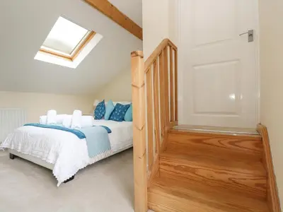 a bedroom with a bed with blue pillows at Little Hamlin in Callington