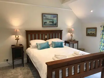 a bedroom with a large bed with blue pillows at Bejowan Cornish Cottage in Newquay