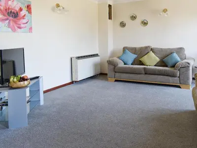a living room with a couch and a television at Haywain - Uk12084 in Saint Endellion