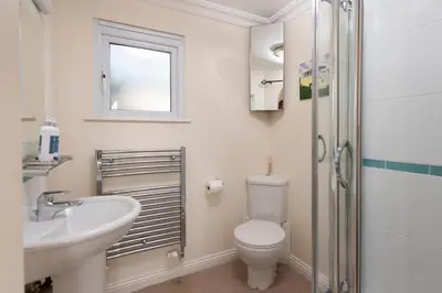 a bathroom with a toilet and a sink and a shower at Waves Apartment, St Ives in St Ives