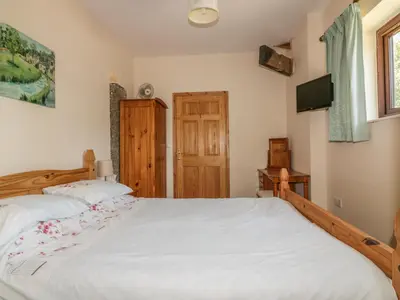 a bedroom with a large bed and a tv at Garras Barn in Truro
