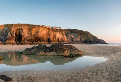 a rock in the sand on a beach at Amaroo in St. Agnes