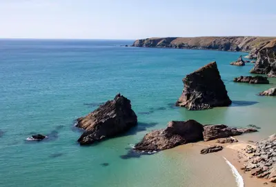 a beach with some rocks in the water at Amaroo in St. Agnes