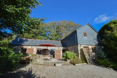a house with a red umbrella in front of it at Church Close Cottage in Gwennap