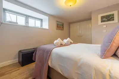 a bedroom with a bed with towels on it at Copperhouse View in Hayle
