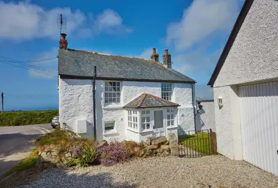 a white house with a window and a fence at Balwest Cottage in Helston