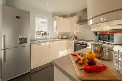 a kitchen with a cutting board with vegetables on it at Sea Folly in Perranporth