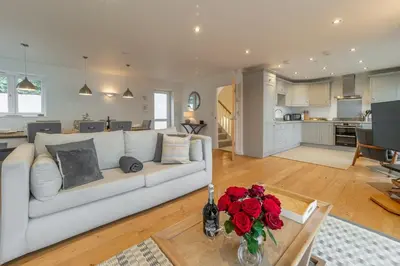 a living room with a couch and a table with roses at Westaway in Portreath