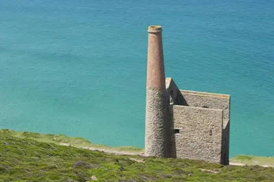 a tower on top of a hill next to the water at Triskel in St. Agnes