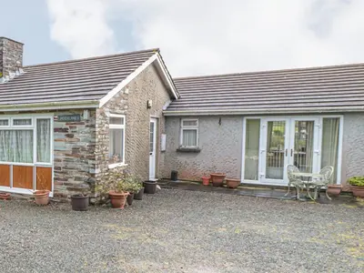 a brick house with a bench in front of it at Little Lanes in Camelford
