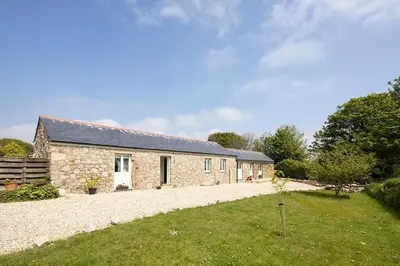 a stone house with a yard in front of it at Cart Shed Cottage in Truro