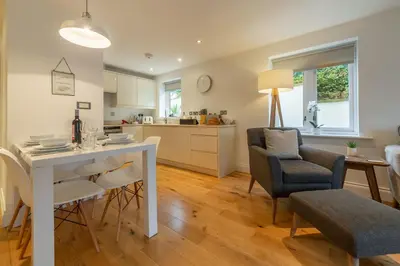 a kitchen and living room with a table and chairs at 3 Sandy Lane in Carbis Bay