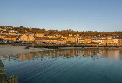 a body of water next to a beach with houses at 3 Sandy Lane in Carbis Bay