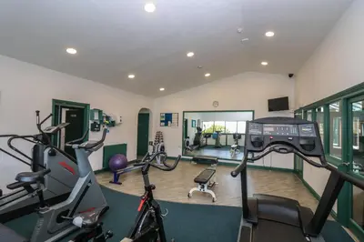 a gym with cardio equipment and bikes in a room at Oyster Cottage in Falmouth