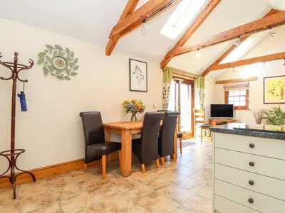 a kitchen and dining room with a table and chairs at Valley View in Helston