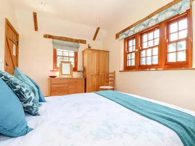 a bedroom with a large bed and a mirror at Valley View in Helston