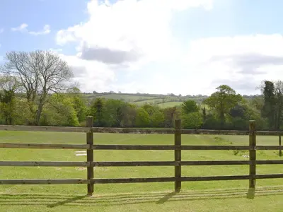 a wooden fence in the middle of a field at Hayloft - Ukc4241 in Lanreath