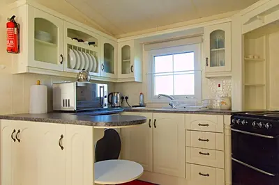 a kitchen with white cabinets and a microwave at Coosewartha Countryside Holiday Rental in Truro