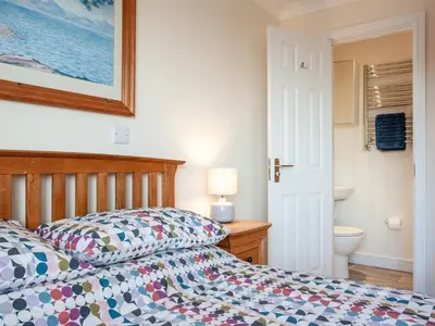 a bedroom with a bed and a bathroom at The White House in Poundstock