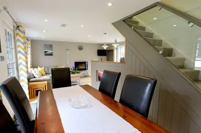 a dining room with a table and chairs and a living room at 20 Tudor Court 