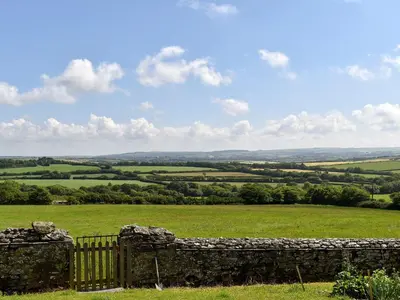 a stone fence in front of a green field at Stable Cottage - Uk12088 in Saint Endellion
