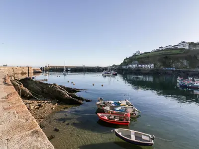three boats are docked in the water next to a beach at Midships in St Austell