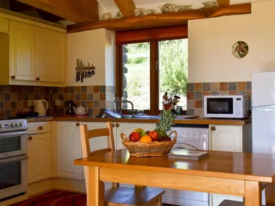 a kitchen with a table with a basket of fruit on it at Round House - Uk12083 in Saint Endellion