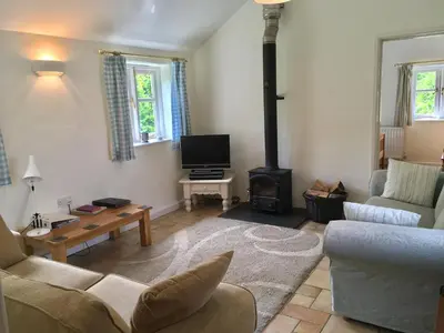a living room with a couch and a wood stove at Little Pengelly Farm in Crowan
