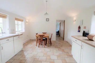 a kitchen and dining room with a table and chairs at Little Pengelly Farm in Crowan