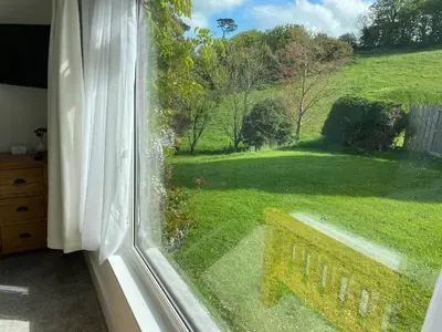 a window with a view of a green yard at Kerryanna Country House Bed and Breakfast in Mevagissey