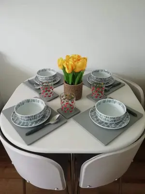 a white table with plates and flowers on it at Chalet 26 Widemouth Bay in Bude