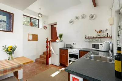 a kitchen with a sink and a stove top oven at The Snug at Cornish Barn Holidays in Truro