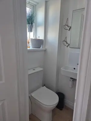 a white bathroom with a toilet and a sink at Number 6 in St Austell