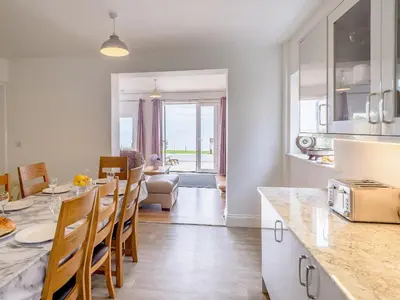 a kitchen and living room with a table and chairs at Beachside, West Yardley House - Uk31200 in Downderry