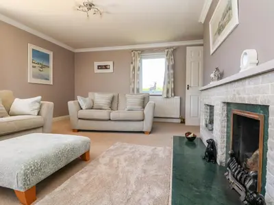 a living room with a fireplace and a couch at Trevore Farmhouse in Truro