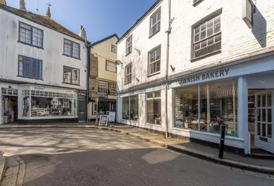 an empty street in a town with buildings at The Old Smoke House in St Austell
