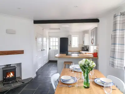 a kitchen and dining room with a table and a fireplace at Summercourt in Launceston