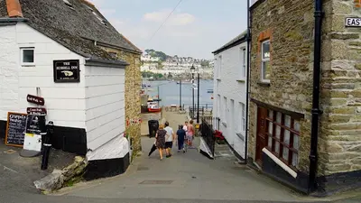 a group of people walking down a street next to buildings at Holiday home, Camelford, Cornwall in Camelford