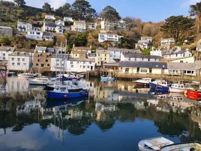 a group of boats are docked in a harbor at Luxury Coastal Shepherds Hut with hot tub, dining dome & a 5 Minute Walk to Pubs and Village in Polperro