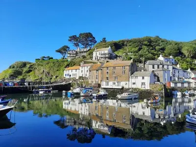 a group of boats in a harbor with houses at Luxury Coastal Shepherds Hut with hot tub, dining dome & a 5 Minute Walk to Pubs and Village in Polperro