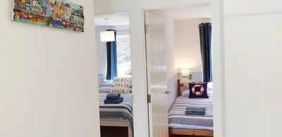 a room with two beds and a mirror at Amazing Granite Henge and Swimming Pool in Looe