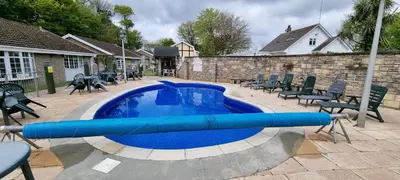 a swimming pool with a blue tube in it at Amazing Granite Henge and Swimming Pool in Looe