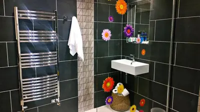 a bathroom with a sink and flowers on the wall at The Shire House in Lostwithiel