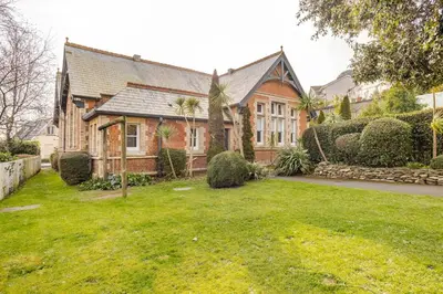 a large brick house with a green yard at Charming Summerhouse Annexe in lush gardens in Fowey in Fowey