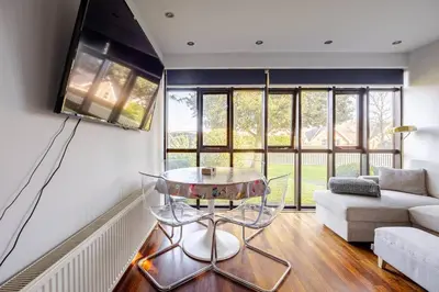 a living room with a glass table and a couch at Charming Summerhouse Annexe in lush gardens in Fowey in Fowey