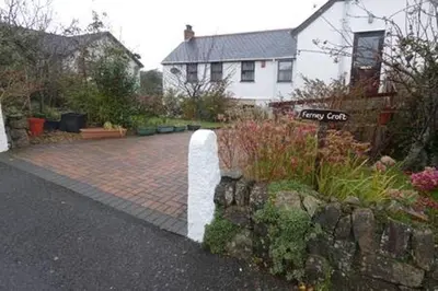 a house with a brick yard with a stone wall at Ferney Croft in Saint Erth